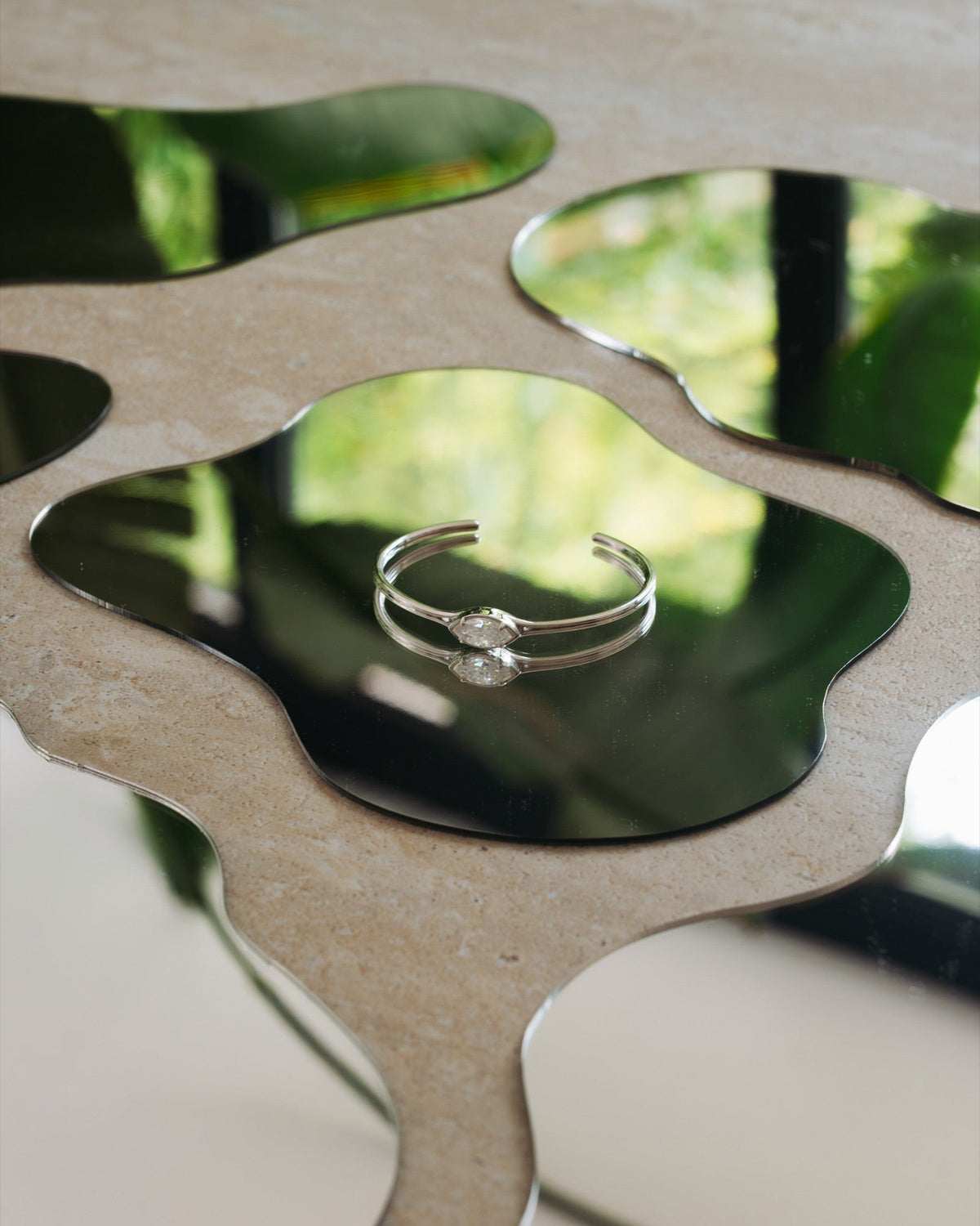 Bracelet Jacques en plaqué argent, posé sur un miroir