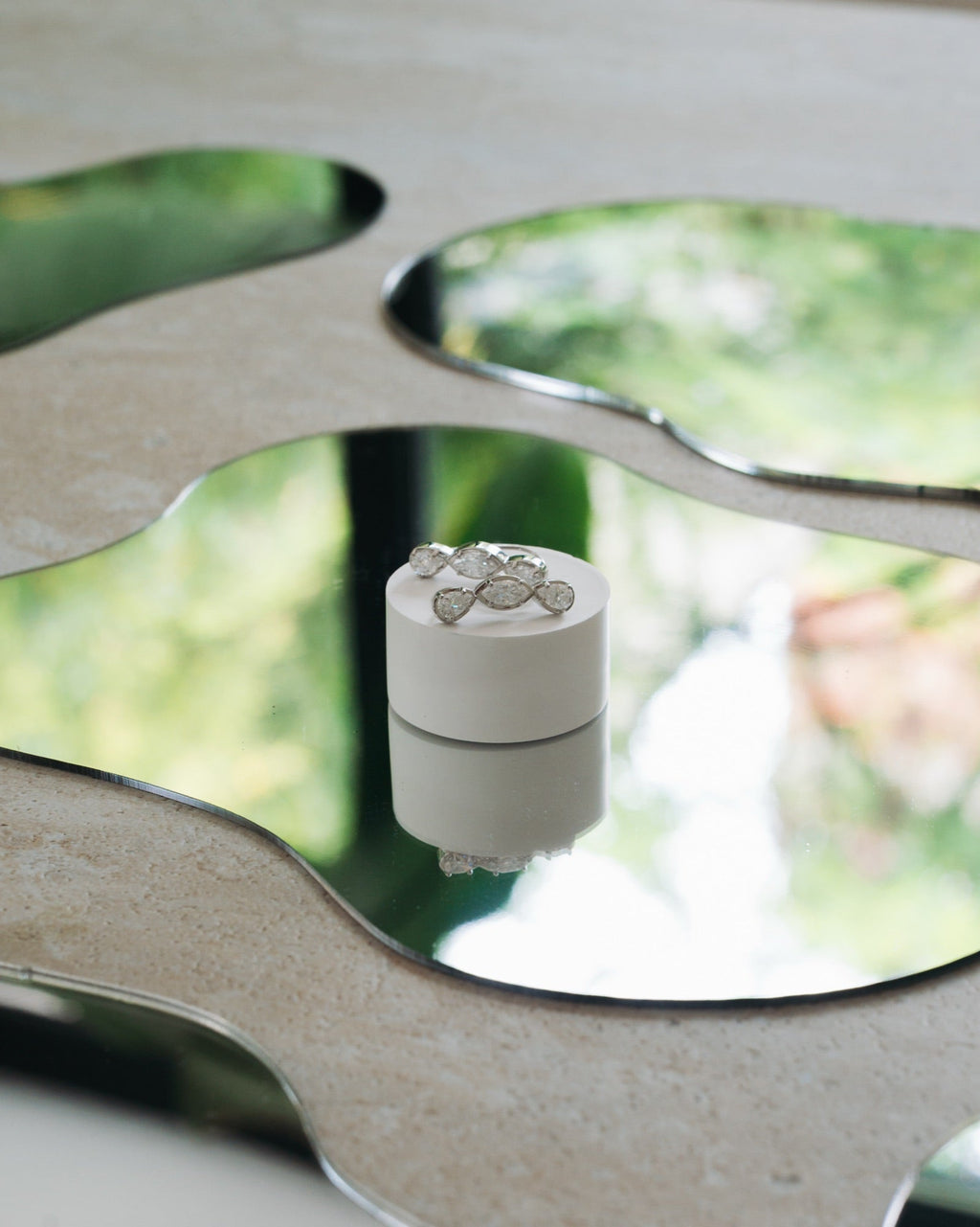 Boucles d'oreilles Jeanne en plaqué argent, posées sur un miroir