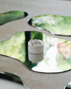 Boucles d'oreilles Jeanne en plaqué argent, posées sur un miroir