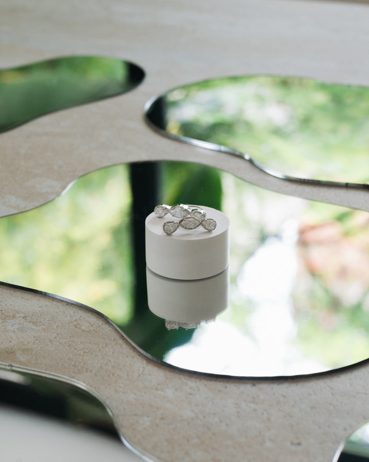 Boucles d'oreilles Jeanne en plaqué argent, posées sur un miroir