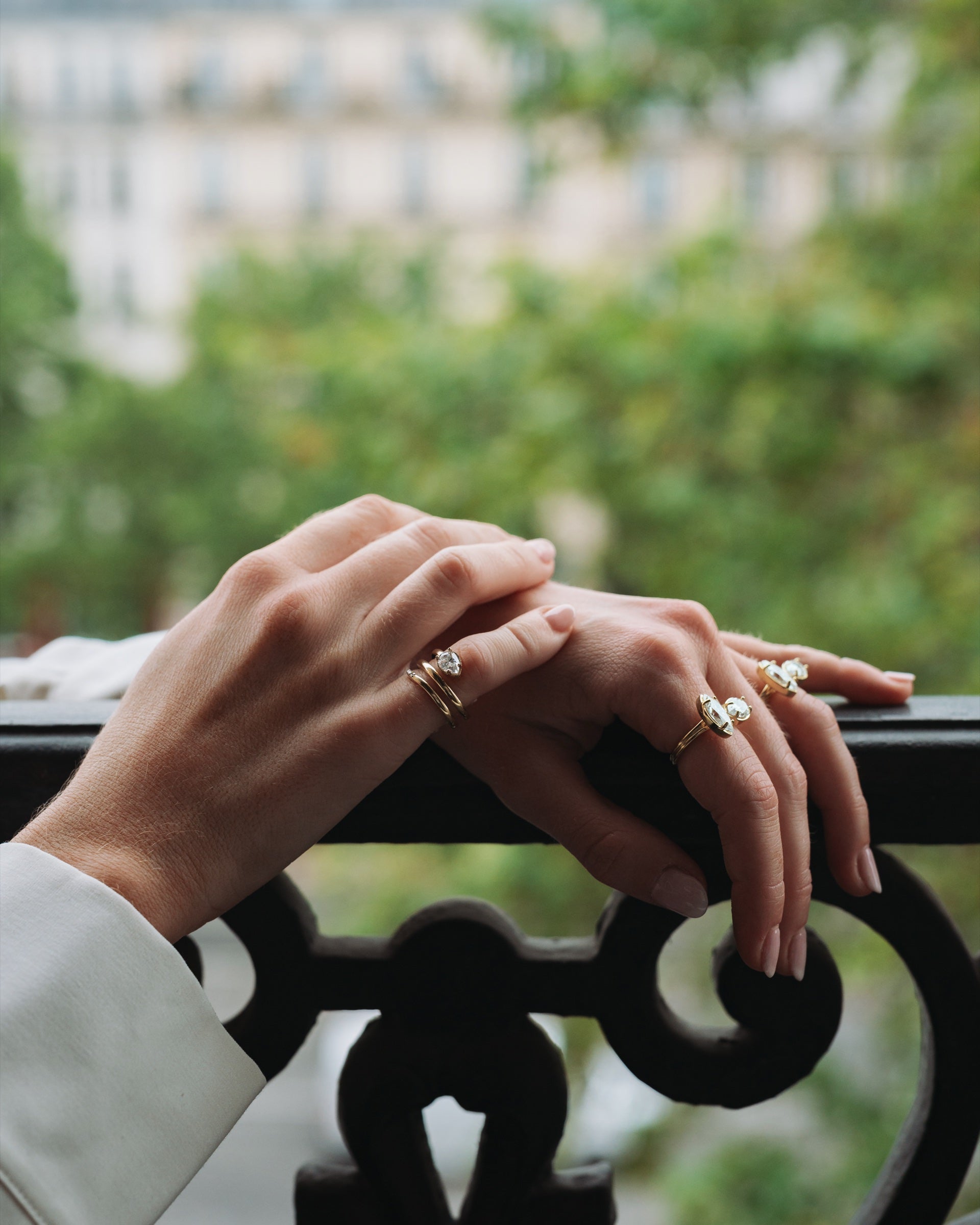 Mains portant les bagues GASSION, sur un balcon parisien